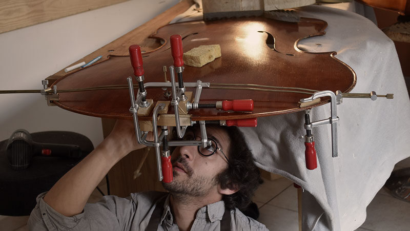 Portrait du luthier Pierre MIchel avec une contrebasse